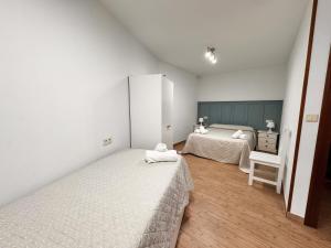a bedroom with two beds and a dresser at Apartamentos Rurales LLeguera in Llanes