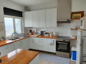 a kitchen with white cabinets and a stove top oven at Sea Bay House in Lagoa +18 photos