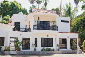 a white house with palm trees in the background at Casas Blancas, Planta Baja in Todos Santos