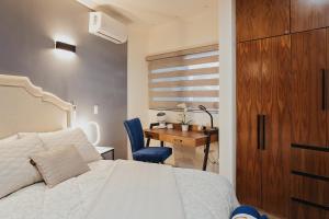 a bedroom with a bed and a desk and a table at Casas Blancas, Planta Baja in Todos Santos
