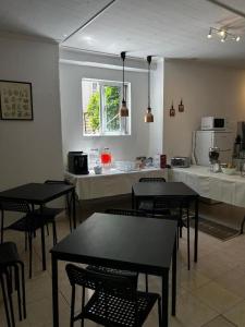 a kitchen with black tables and chairs in a room at Samps Hostel in Lisbon