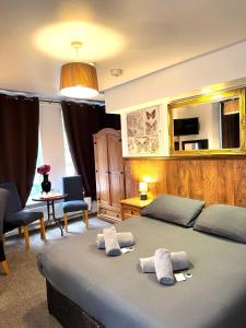 a bedroom with two beds with towels on top of it at Riverside Hotel in Norwich