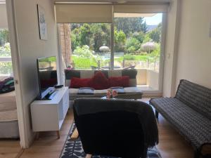 a living room with a couch and a television at Departamento en papudo in Papudo