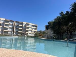 an empty swimming pool in front of a building at Departamento en papudo in Papudo