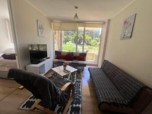 a living room with a couch and a tv at Departamento en papudo in Papudo