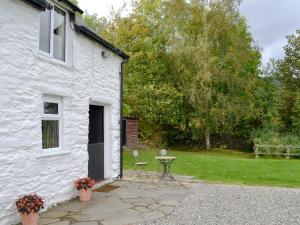 a white house with a patio and a table at Crogen Bryn Awel in Llandrillo +7 photos