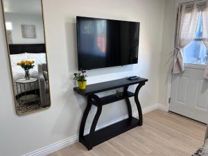 a black console table with a television on a wall at Yellow Gate Executive Retreat in San Jose +8 photos