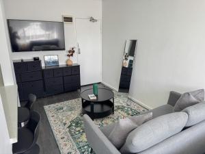 a living room with a couch and a table at Clean Bright Studio Apartment - Walkable Location in Melbourne