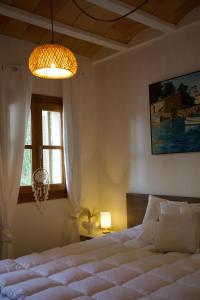 a bedroom with a white bed and a window at Finca Ses Eres in Artá +37 photos