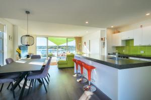 a kitchen and dining room with a table and chairs at Mapua Wharfside Apartments in Mapua