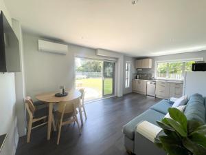 a living room with a blue couch and a table at Beachside Bliss - Modern Luxury in Napier