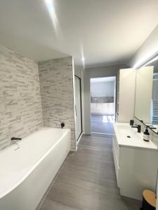a bathroom with a white tub and two sinks at Beachside Bliss - Modern Luxury in Napier +25 photos