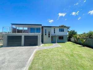 a bedroom house with a large yard at Beachside Bliss - Modern Luxury in Napier