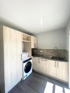 a kitchen with a sink and a dishwasher in it at Beachside Bliss - Modern Luxury in Napier