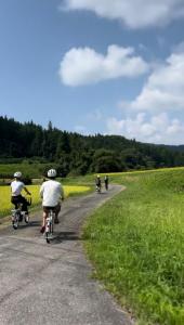 a group of people riding bikes down a road at guesthouse Emi 笑み NIKKO in Nikko