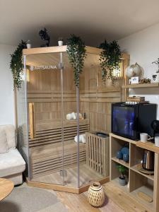 a living room with a entertainment center with a tv at Wood Spa Wellness Suite mit Whirlpool & Sauna nahe Göttingen in Rosdorf