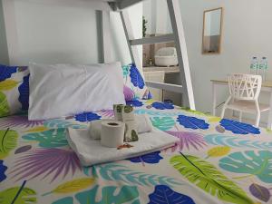 a bed with a tray with towels and two cups on it at JAG Homes in Puerto Princesa City