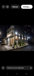 a picture of a house at night with lights at Lofts portal 225 unid 01 in Recife +11 photos