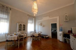 a dining room with two tables and chairs in it at RESIDENZA DEGLI ARTISTI - La Maison in Trieste