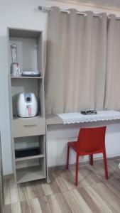 a room with a table and a red chair at Lofts portal 225 unid 01 in Recife