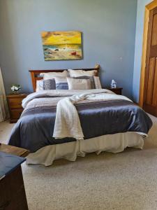 a bedroom with a bed with a painting on the wall at Belvedere Bed & Breakfast in Winton