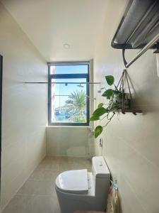 a bathroom with a toilet and a window at Đầm Nại Hotel in Ninh Hải