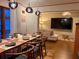 a living room with a large table and chairs at Snoa Kitanomine - スノア キタノミネ - in Furano