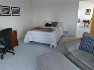 a bedroom with a bed and a chair and a couch at Moosedance 2 bedroom suite, beautiful views in Anchorage