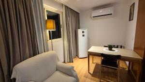 a small room with a table and a white refrigerator at Barra First Class in Rio de Janeiro