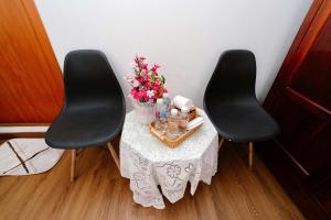 two black chairs and a table with flowers on it at Hotel Tri Tôn in Tri Tôn
