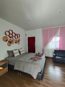 a bedroom with a large bed and a couch at บ้าน พัก ดี เกาะล้าน Ban Phak D Koh Larn in Ko Larn
