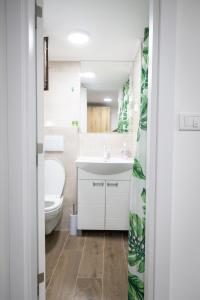 a bathroom with a white sink and a toilet at Apartman centar 18 in Ub