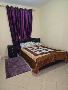 a bed in a room with a purple curtain at ALmas apparemment in Ifrane