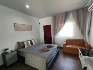 a small bedroom with a bed and a couch at บ้าน พัก ดี เกาะล้าน Ban Phak D Koh Larn in Ko Larn