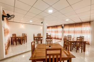 a dining room with wooden tables and chairs at Kandy Golden Gate Resort in Kandy