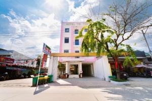 a pink building with a palm tree in front of it at Hotel Tri Tôn in Tri Tôn