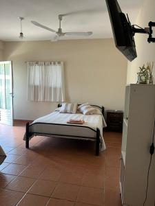 a bedroom with a bed and a flat screen tv at Casa Lavanda in Embalse