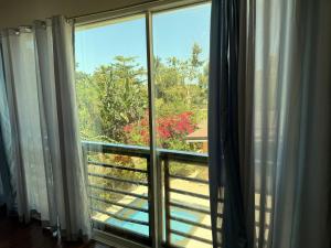 a window with a view of a garden at Blue Villa - Entire House with Private Pool in Panglao Island