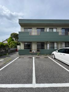 a white car parked in a parking lot in front of a building at BreakPoint in Ichinomiya