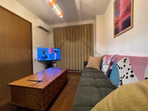 a living room with a couch and a tv at BreakPoint in Ichinomiya