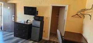a room with a kitchen with a refrigerator and a tv at Indian Mound Motel in Fairmont City