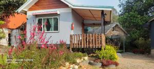 a house with a porch and flowers in the yard at เล่าจู in Ban Na Yang