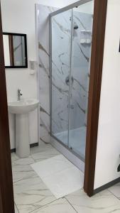 a bathroom with a shower and a sink at MarDani Guesthouse & Car Rental - FREE SJO Airport Shuttle in Alajuela