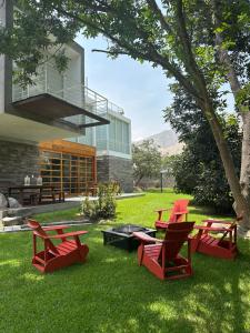 a group of red chairs and a fire pit in a yard at Zen Home & Garden House in Cieneguilla