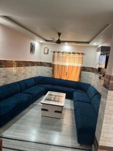 a living room with a blue couch and a table at Hotel Dubeyinn in Katra