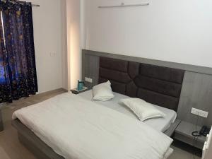 a bedroom with a large bed with white sheets and pillows at Hotel Dubeyinn in Katra