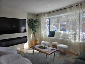 ein Wohnzimmer mit Flachbildfernseher und einem Tisch in der Unterkunft Upper-Level Oasis- Ideal for 2026 World Cup visitors in Norwood
