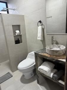 a bathroom with a white toilet and a sink at Hospedaje Zerimar in Puerto Baquerizo Moreno