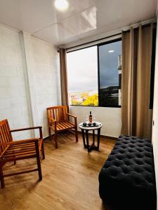 a living room with two chairs and a table and a window at Hospedaje Zerimar in Puerto Baquerizo Moreno