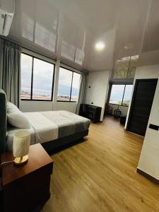 a large room with a bed and large windows at Hospedaje Zerimar in Puerto Baquerizo Moreno